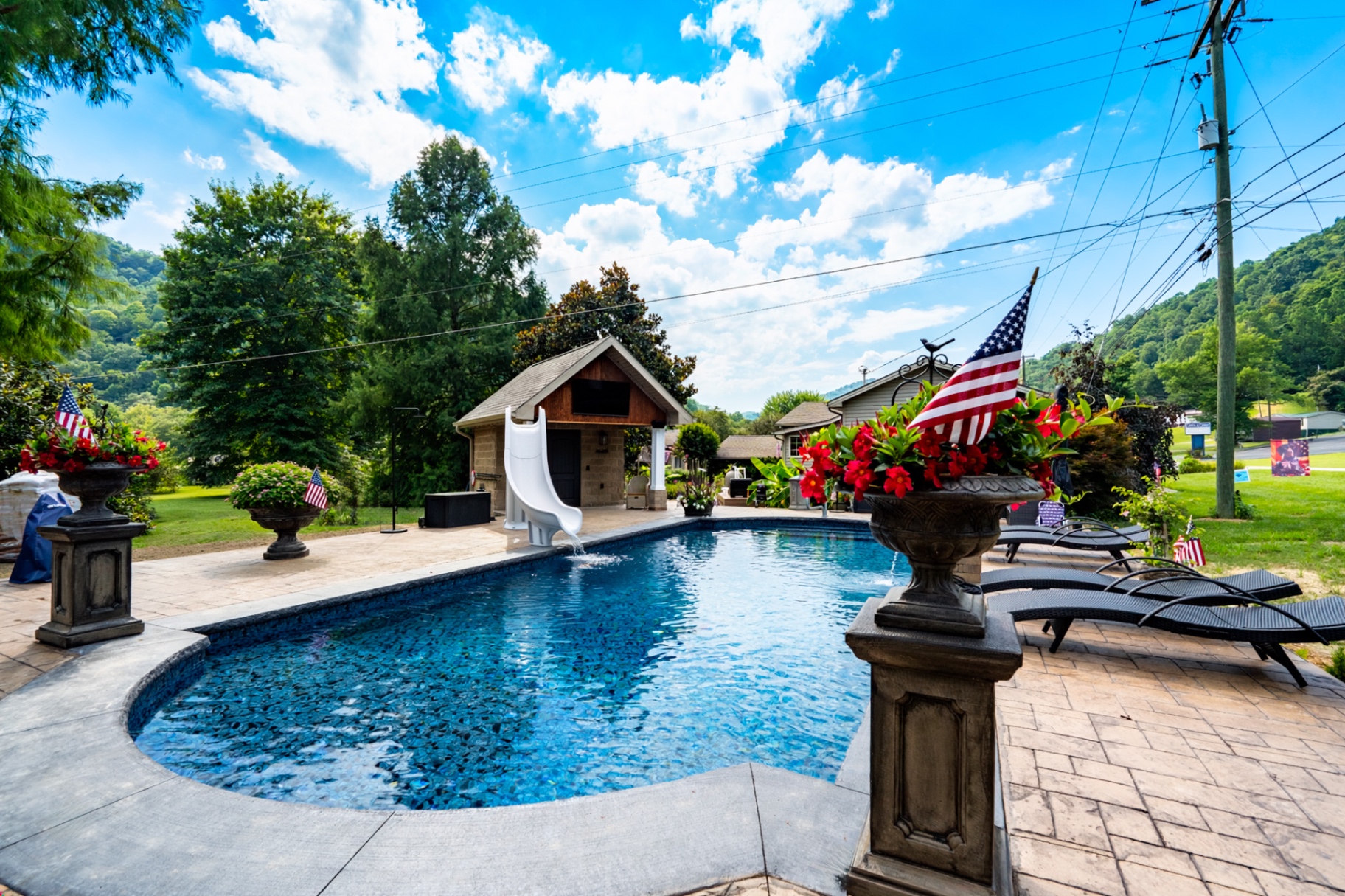 Custom pool build with flag planters and pool house
